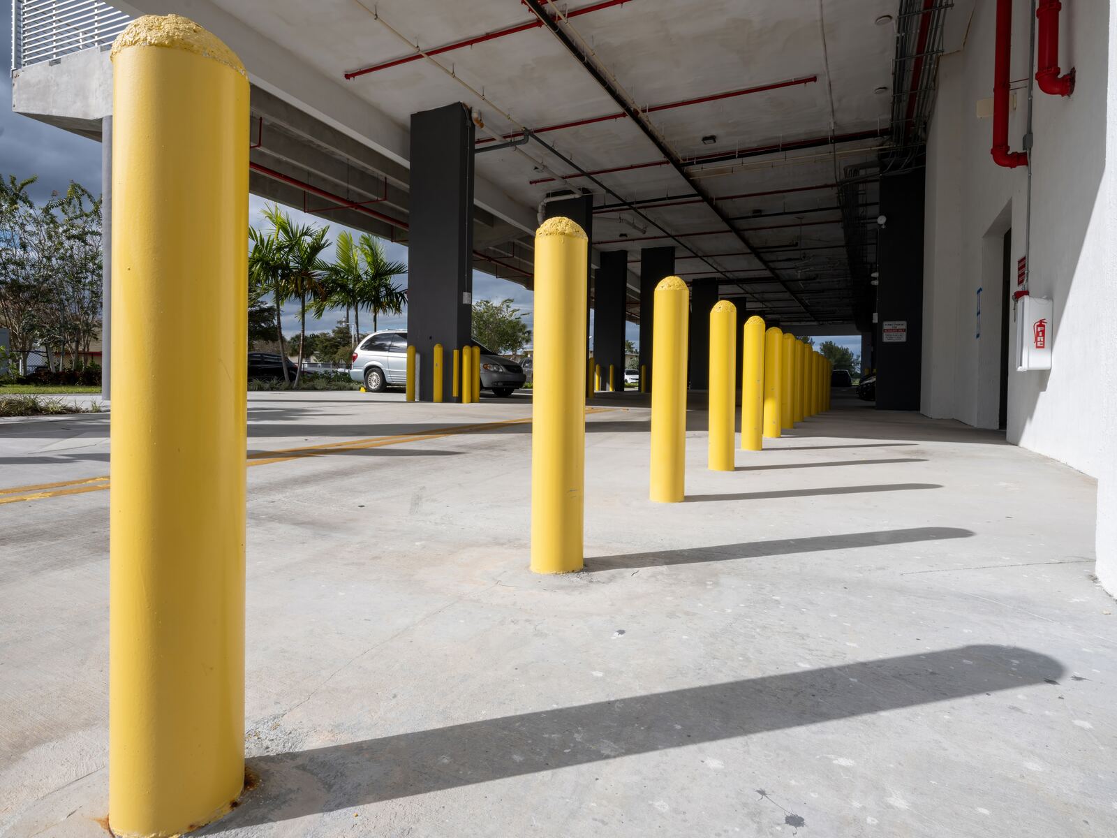Row of yellow steel bollards in a commercial parking structure