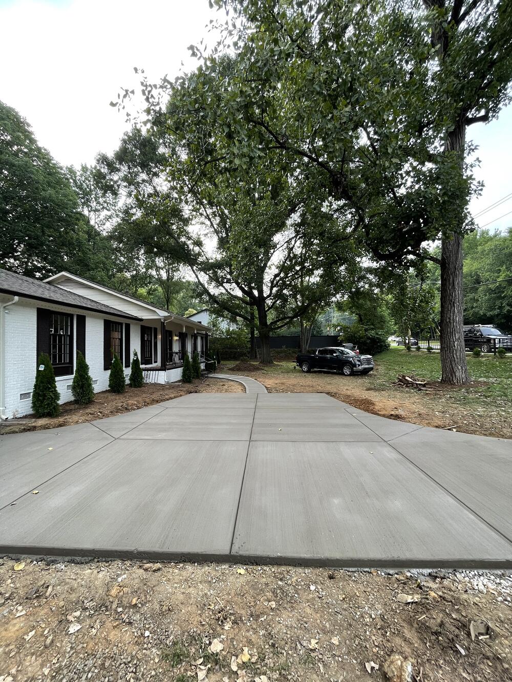 Wide concrete driveway with saw-cut joints in front of a ranch house