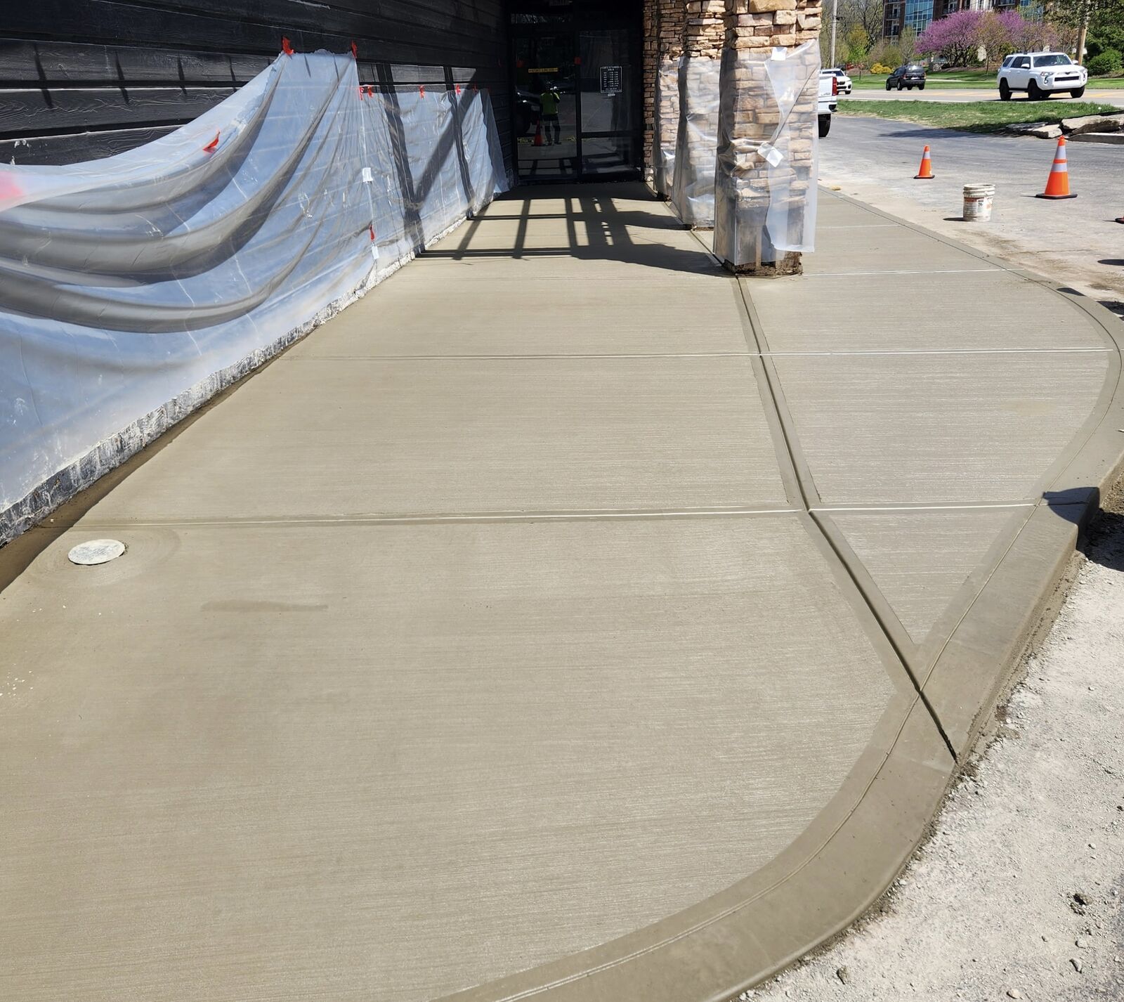 New concrete sidewalk with a curved curb at a commercial entrance